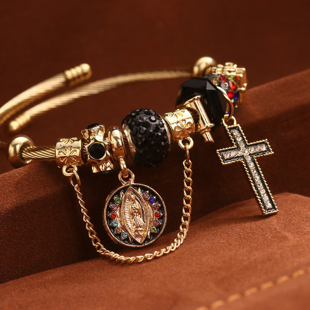 Close view of the black cross charm cuff bangle showing jet pave bead, safety chain and oval medallion