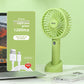 USB rechargeable handheld fan running hands free on a desk while charging