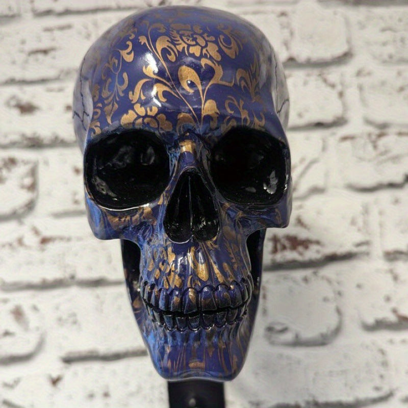 Blue and gold filigree resin skull on a metal wall bracket for hanging a helmet