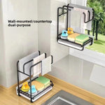 Black two level kitchen rack on a wall and a second on a counter, with cloths, sponges and a brush, wall or countertop use