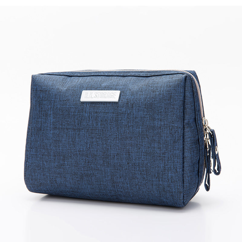 Travel cosmetic bag in Oxford cloth with a side grab handle and elastic bottle loops