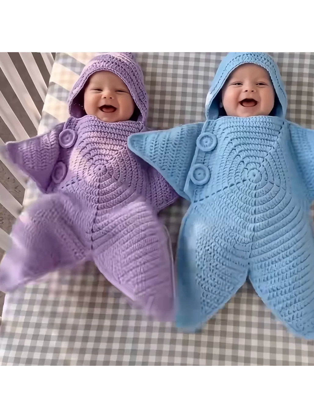 Purple and blue crochet star baby buntings with hoods worn by babies in a checked crib