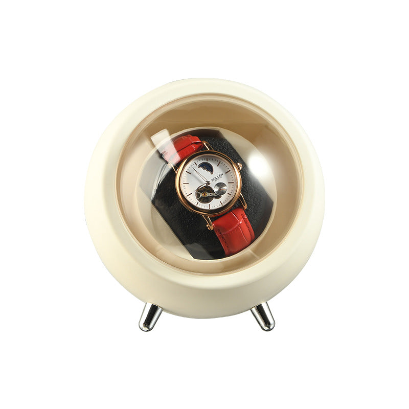 Cream Space White watch winder capsule on three metal feet with a red strap watch inside