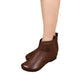 Woman's leg in a brown soft leather ankle boot with a side strap, cut out on a white background