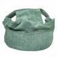 Small dog wearing the corduroy baseball cap with the brim at the front