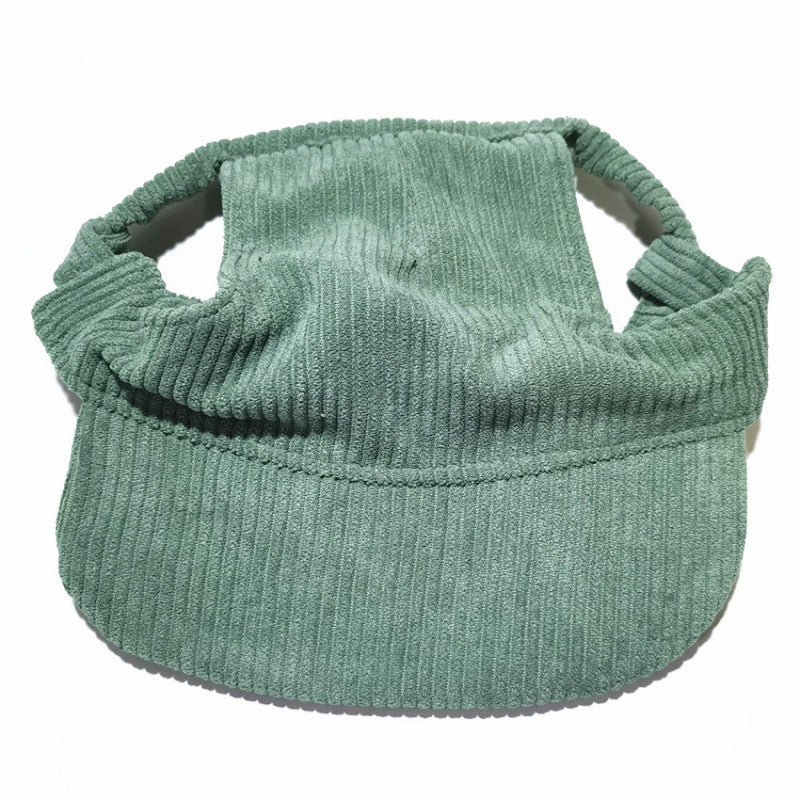Small dog wearing the corduroy baseball cap with the brim at the front