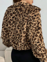 Cropped leopard print vegan fur jacket worn open over a black bodysuit by a studio model