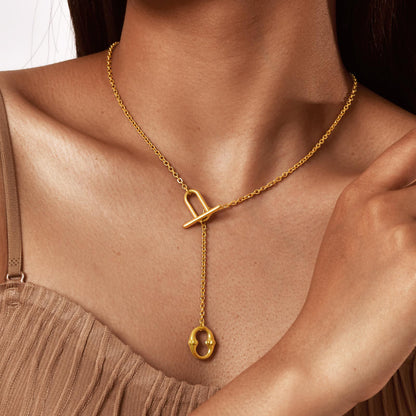 Gold tone stainless steel toggle lariat necklace, front view with oval drop pendant