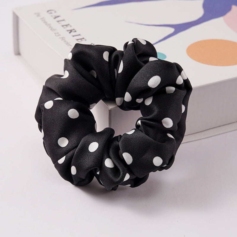 Several solid color satin scrunchies grouped together