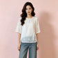 Tonal white floral embroidery across the front of an ivory summer shirt