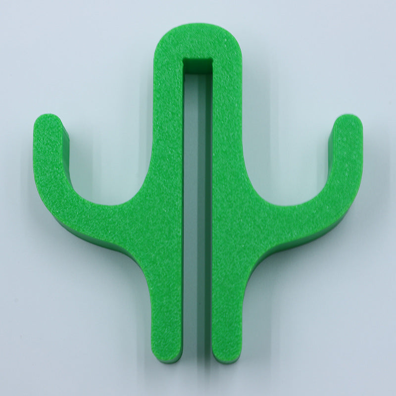Green resin double hook with an arm on each side, seen from the front on a light background