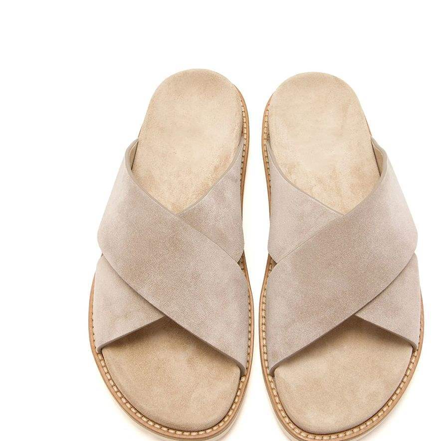 Pair of light taupe suede cross-strap slide sandals seen from above, with sand suede footbeds and cream soles