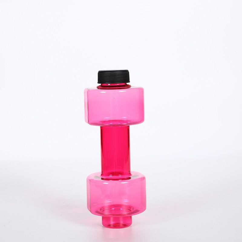 Green translucent dumbbell shaped water bottle standing on end on a white surface