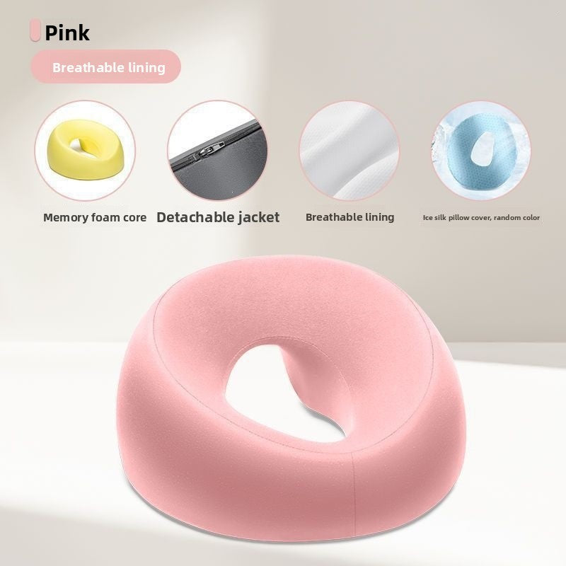 Gray memory foam face rest pillow resting on a surface, showing the open center and rounded ring shape