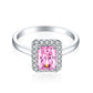 Front view of an emerald cut pink stone halo ring on a plain S925 sterling silver band, rhodium finish