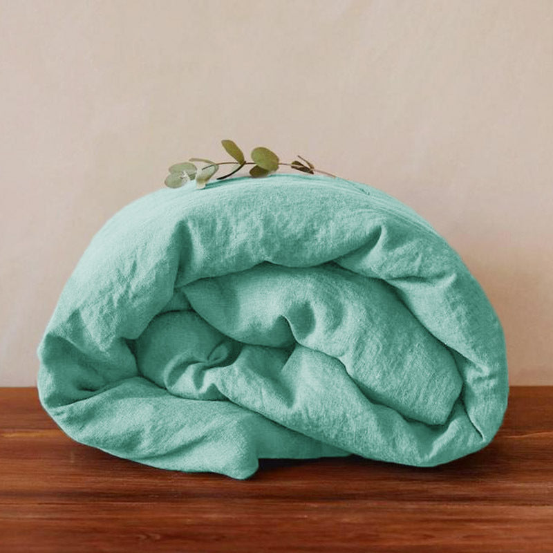 Washed pure linen duvet cover draped over a bed with matching linen pillows