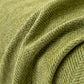 Chenille herringbone sofa cover laid over an armchair in a living room