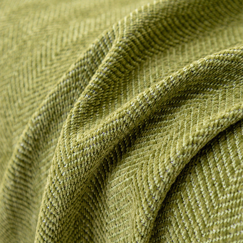 Chenille herringbone sofa cover laid over an armchair in a living room