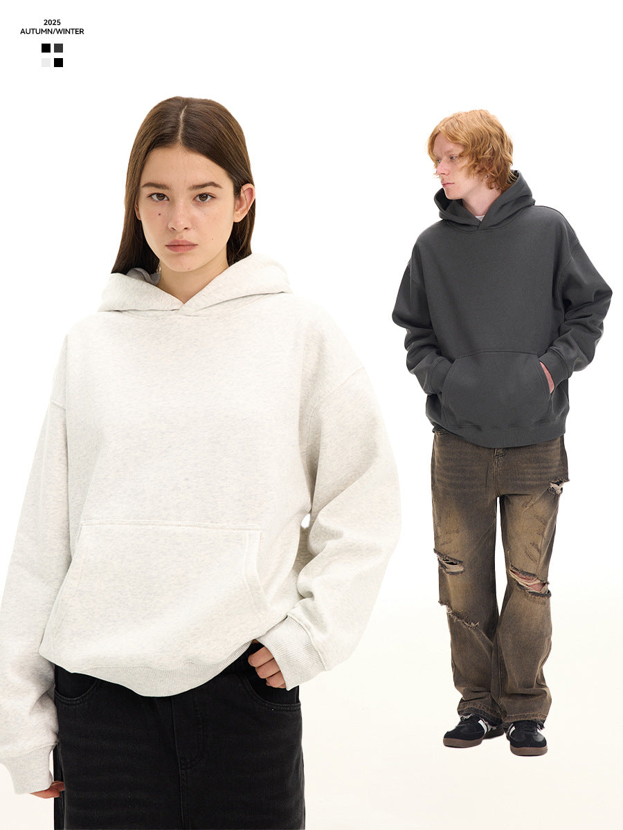 A woman in a white pullover hoodie and a man in a charcoal hoodie, both with wide trousers, on a white background