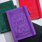 Zodiac embossed A5 planner notebooks in green, red, purple, and black shown together