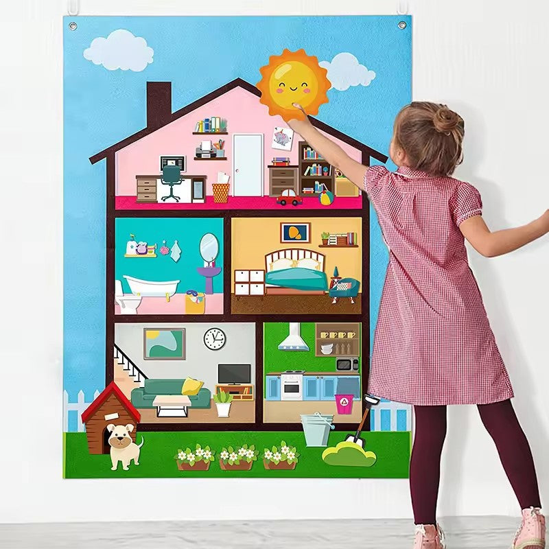 Girl arranging felt furniture on a dollhouse room themed felt story board hung on the wall