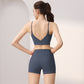 Back view of a woman in a blue gray V-back sports bra and high-waist shorts set, size M option