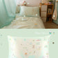 Mint elephant silk pillowcase on a mint bed with an illustrated animal print