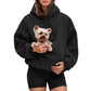 Woman in a black fleece hoodie holding a small dog tucked into the front pouch pocket
