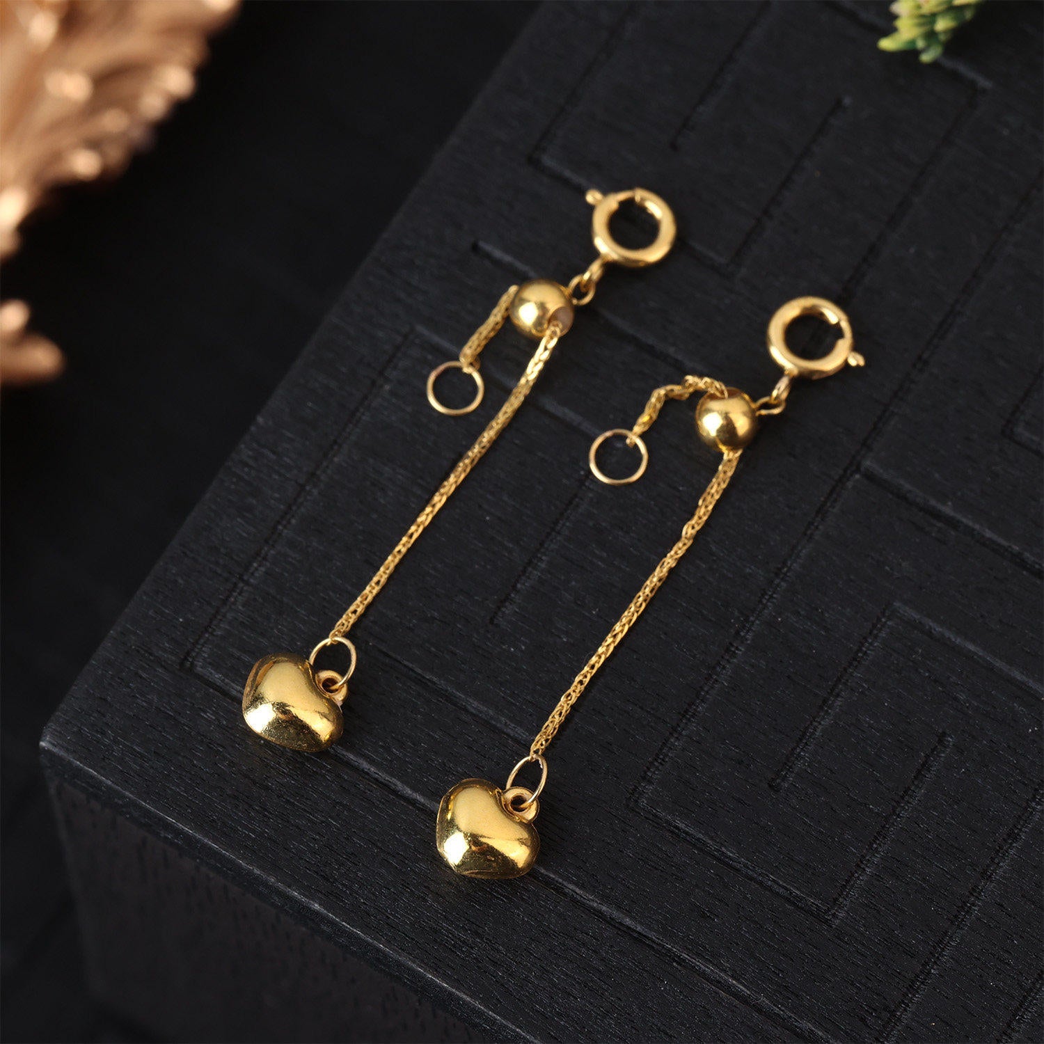Gold plated heart necklace under soft studio light on a plain surface