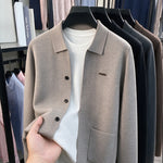 Taupe knit men's cardigan with turn-down collar and three black buttons on a hanger over a white tee