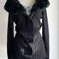 Close up of the plush collar and round black buttons on a black ribbed knit cardigan