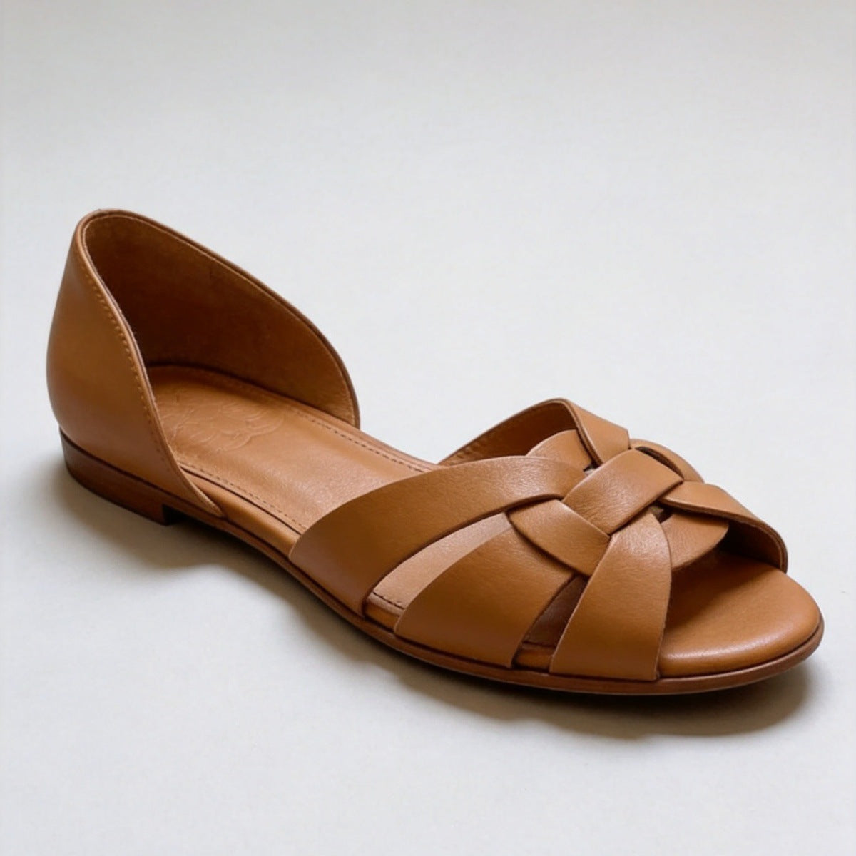 Fish mouth peep toe of a woven artificial leather flat with basket weave straps