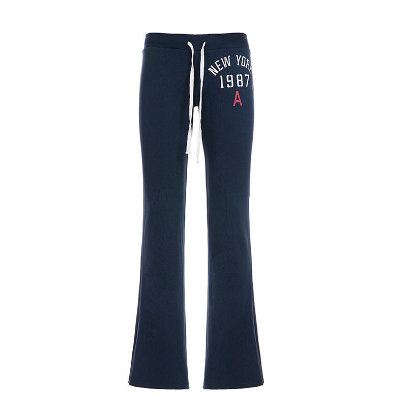Navy flared drawstring sweatpants with white New York 1987 print flat on a white background