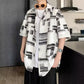 White camp shirt with black abstract blocks, sleeves finishing near the elbow