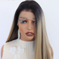 Close front view of a long straight lace front wig with dark roots, lace hairline and blonde and brown sections