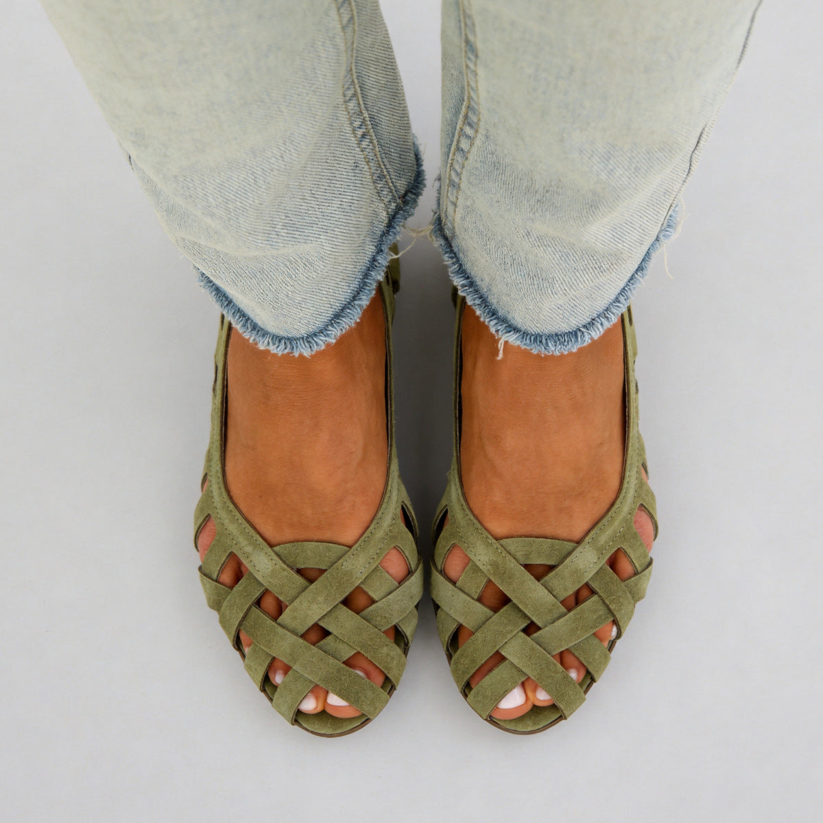 Pair of womens woven flat sandals set together showing the interlaced strap upper