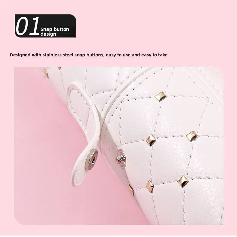 Close view of the stainless steel snap button strap on the studded white PU leather brush holder lid