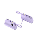 Two purple mini capsule power banks with digital displays and lanyard loops, one standing and one lying down