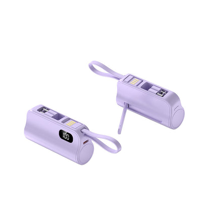 Two purple mini capsule power banks with digital displays and lanyard loops, one standing and one lying down