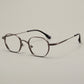 Top down view of the folded titanium eyeglasses frame on a plain surface