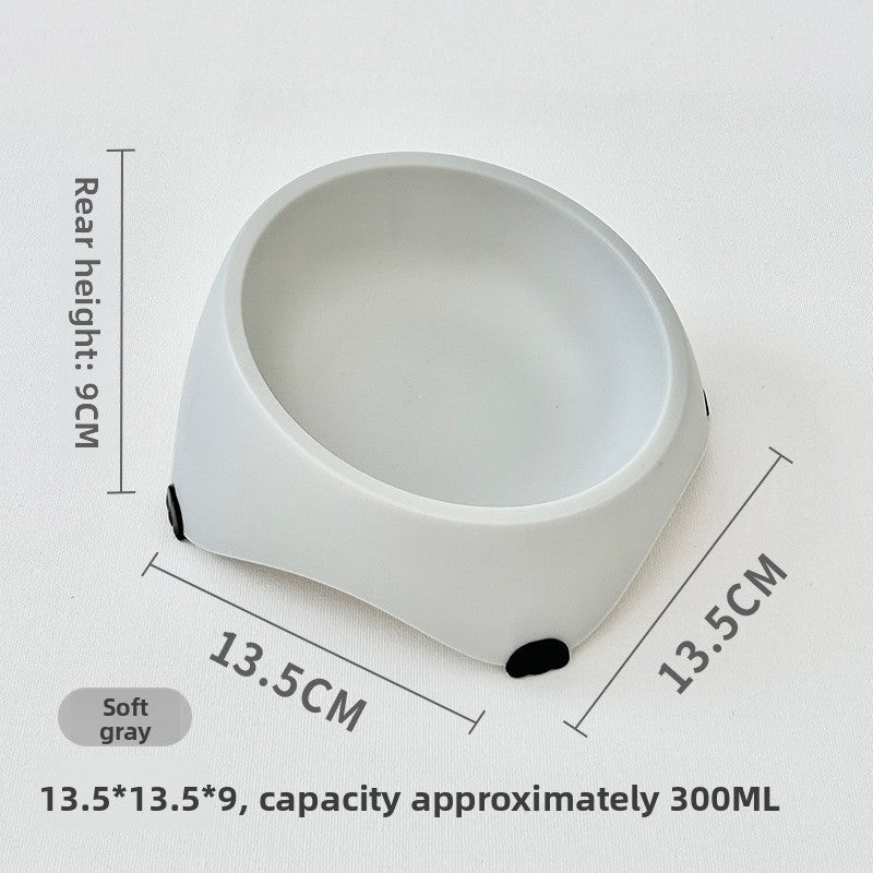 White tilted stainless steel cat feeding bowl on a kitchen floor