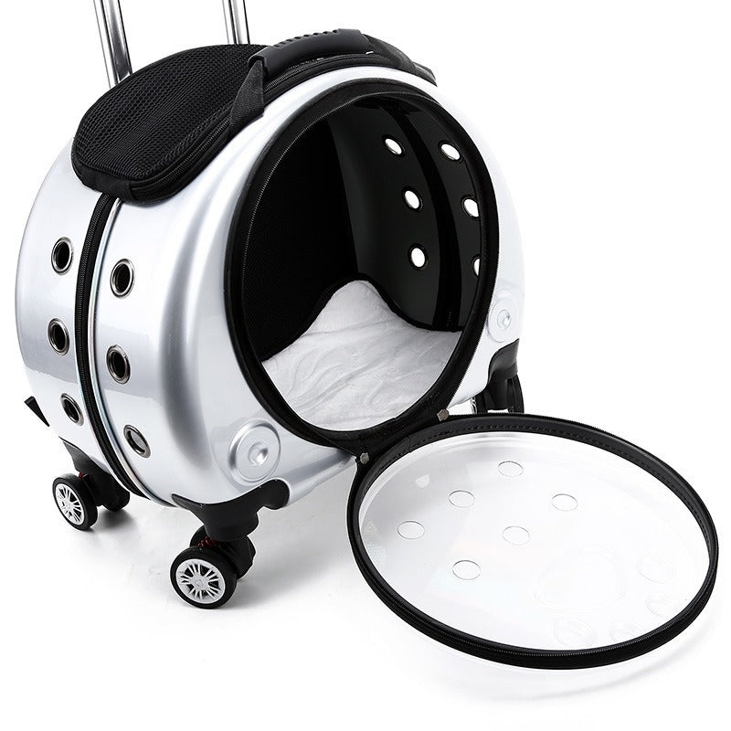 Silver capsule pet carrier with its round door off, showing the vent holes, mesh top panel and wheels