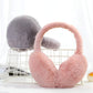 Pink and gray plush earmuffs on a white wire rack, with the pink pair open and the gray pair folded