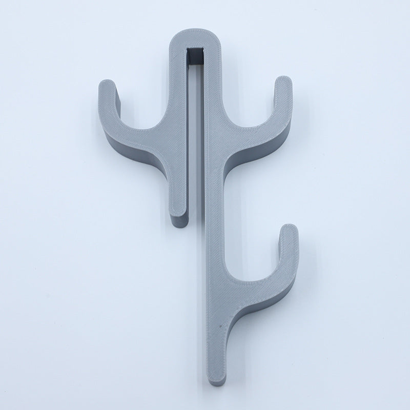 Gray resin three hook with three arms, seen from the front on a light background