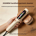 Cream and copper handheld garment steamer held in a hand on a brown paper background