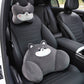 Gray dog headrest pillow on the seat headrest and gray dog lumbar pillow on a black car seat