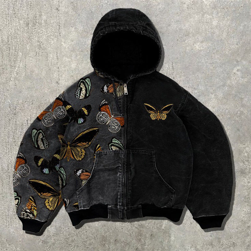 Black and gray hooded zip jacket with a butterfly print on one side and a plain black side on a concrete floor