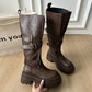 Pair of brown platform boots with buckle straps and a chunky lugged rubber sole