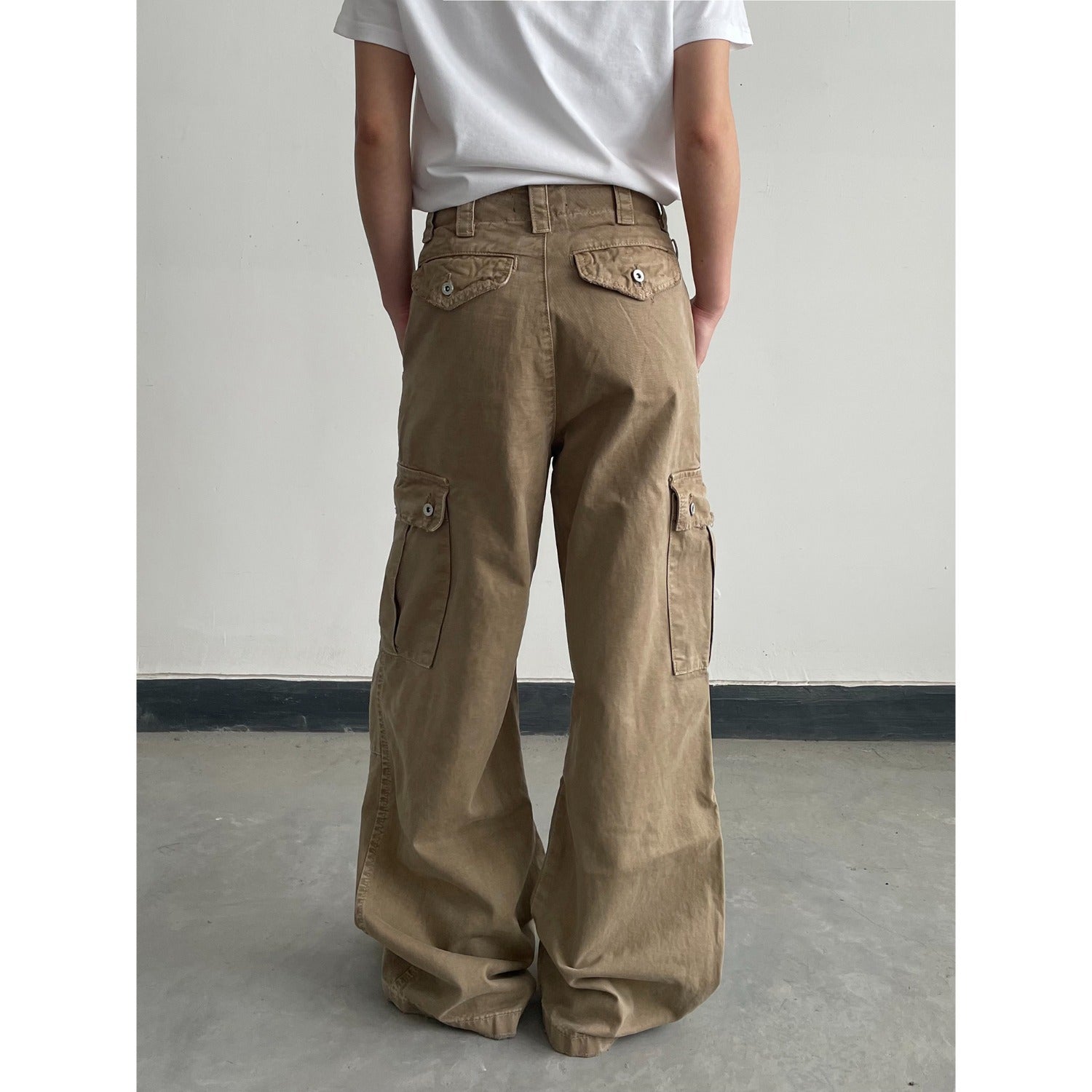 Distressed khaki loose-fit casual pants worn in a relaxed everyday setting