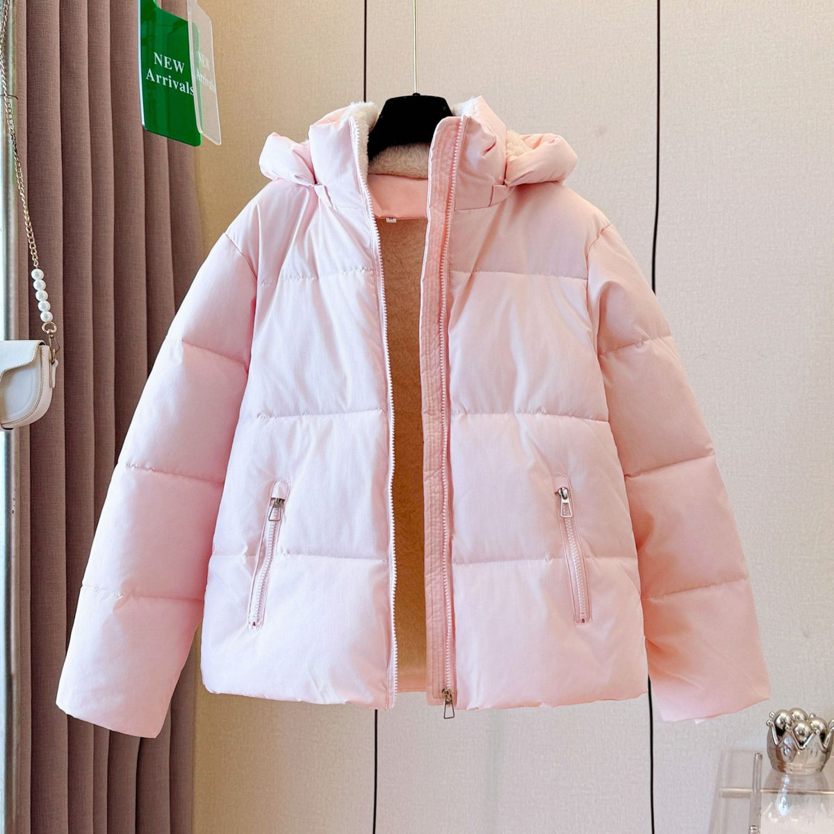 Close view of a zippered front pocket on the quilted short puffer jacket